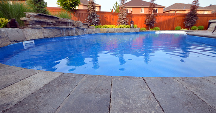 low-angle photo of pool with stone water feature