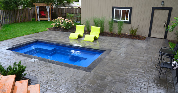 small wading pool with lounge chairs near