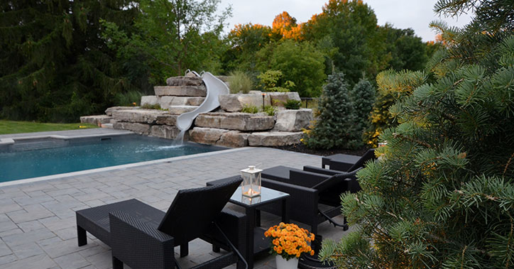 black lounge chairs next to pool with slide